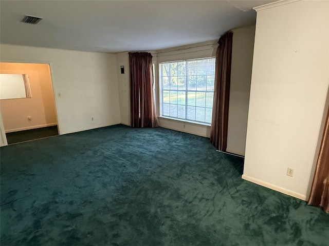 unfurnished room featuring dark colored carpet, visible vents, and baseboards