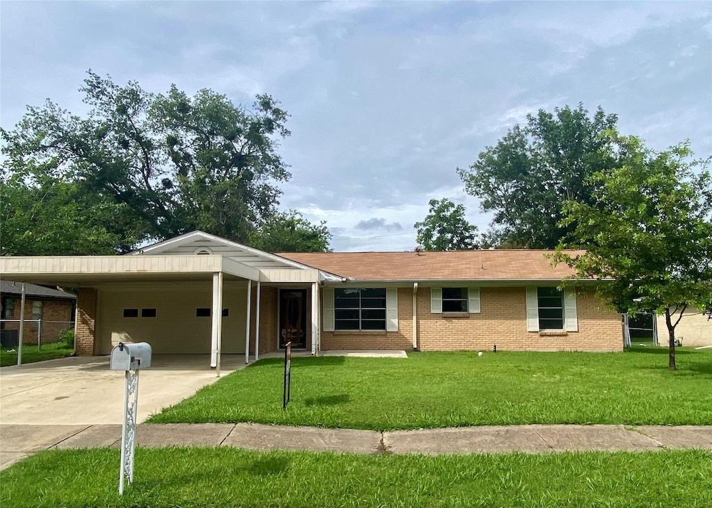 1311 Royal Dr, Kaufman, TX 75142 - ranch-style home featuring an attached garage, driveway, brick siding, and a front yard