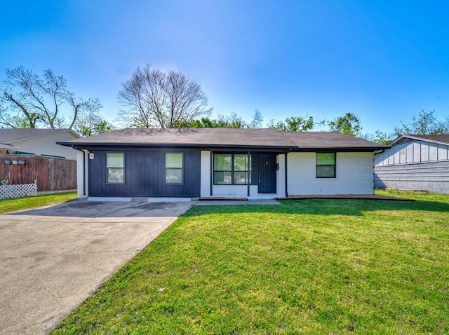 ranch-style home featuring concrete driveway, a front yard, and fence