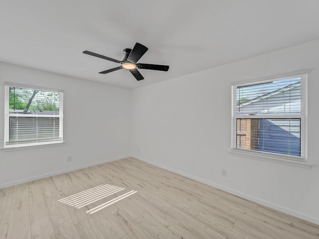 unfurnished room with baseboards, wood finished floors, and a healthy amount of sunlight