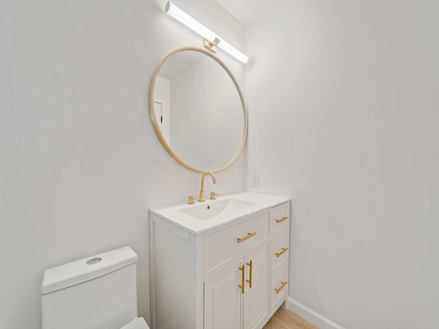 half bath featuring vanity and toilet