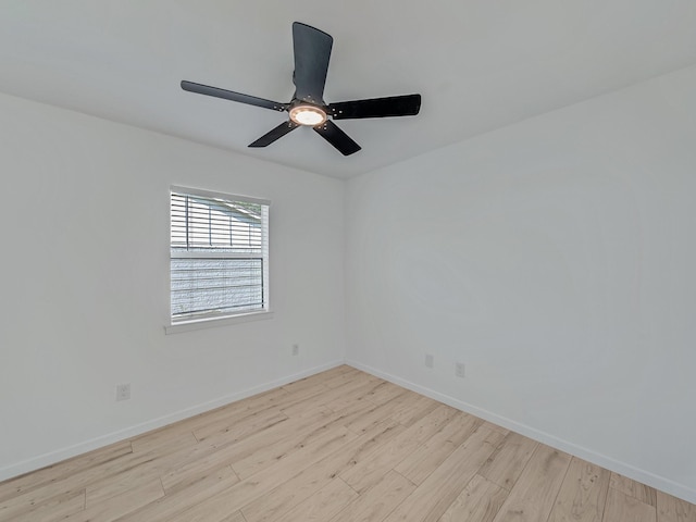 spare room featuring wood finished floors, baseboards, and a ceiling fan