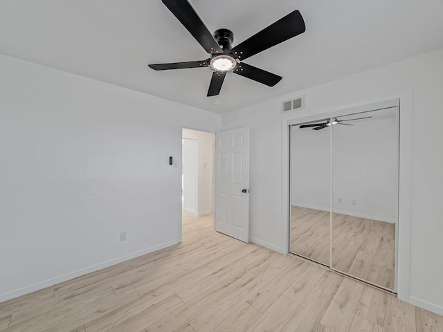 unfurnished bedroom featuring wood finished floors, baseboards, a ceiling fan, and visible vents