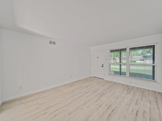 unfurnished room featuring light wood finished floors, baseboards, and visible vents