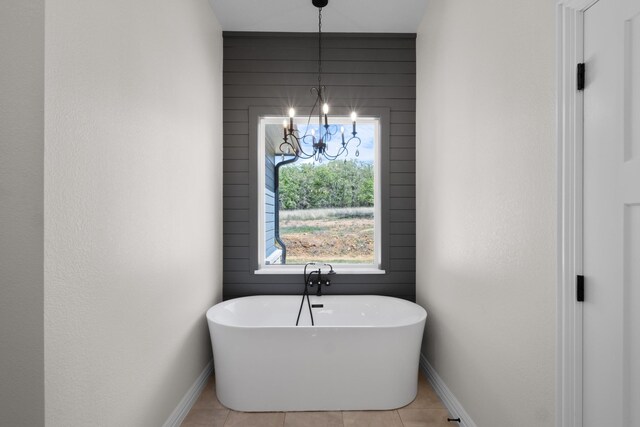 109 Post Oak Cv, Sunset, TX 76270 - full bath with tile patterned flooring, baseboards, a freestanding tub, and a notable chandelier