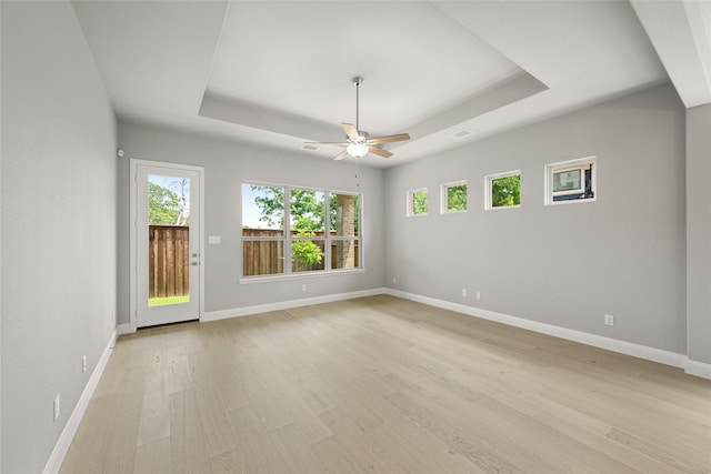 1616 Olympia Ave, Corinth, TX 76208 - unfurnished room featuring a raised ceiling, healthy amount of natural light, a ceiling fan, and light wood-style floors