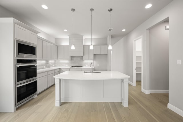 1616 Olympia Ave, Corinth, TX 76208 - kitchen with a sink, stainless steel appliances, tasteful backsplash, light wood-type flooring, and baseboards