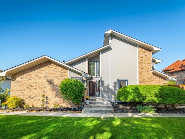view of front of home with a front yard and brick siding