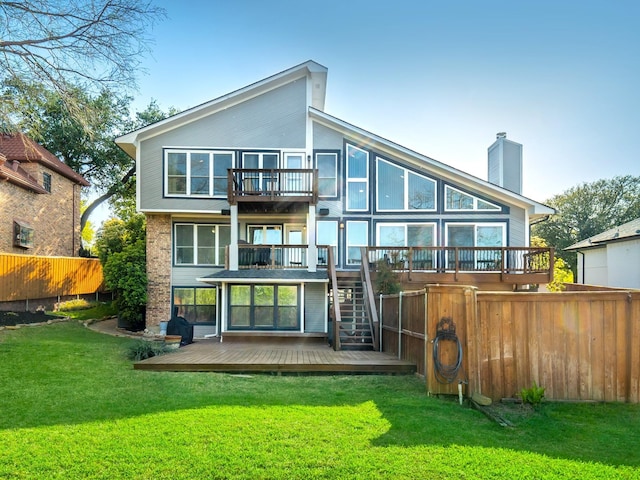 back of property with a deck, a lawn, a chimney, stairway, and fence