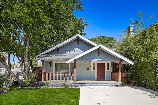 4803 Reiger Ave, Dallas, TX 75246 - view of front of house with roof with shingles, a front yard, and a porch