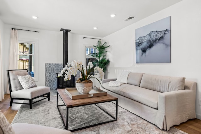 4803 Reiger Ave, Dallas, TX 75246 - living area with recessed lighting, visible vents, a wood stove, and wood finished floors