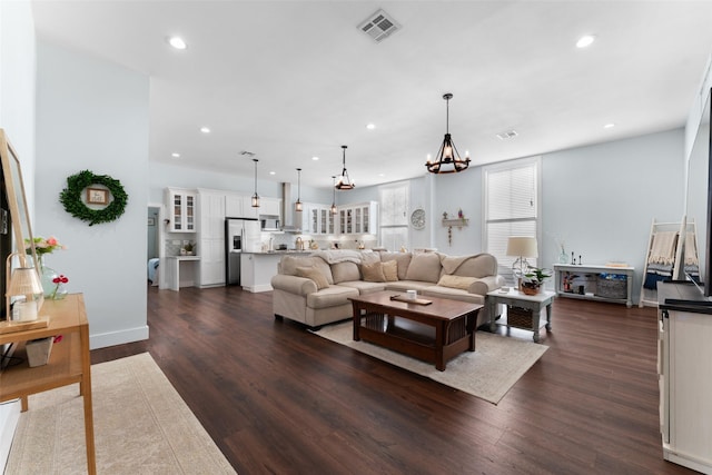 208 Corsicana St, Hillsboro, TX 76645 - living room featuring dark wood-type flooring, recessed lighting, and a chandelier