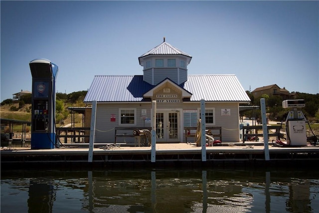 exterior space with french doors, a water view, and metal roof