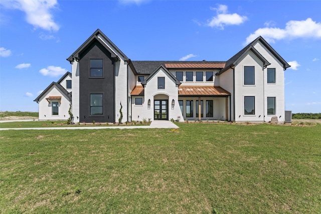 view of front of home featuring french doors, a front lawn, metal roof, and a standing seam roof