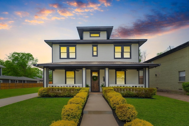 traditional style home with a front yard, a porch, and fence