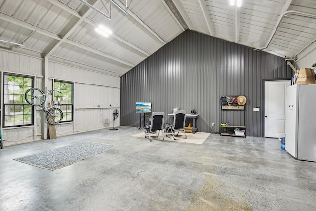 garage featuring metal wall and freestanding refrigerator