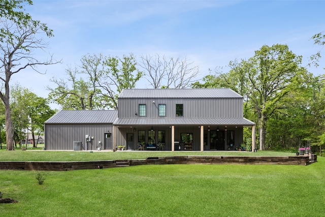 back of house with a yard, metal roof, and central AC unit