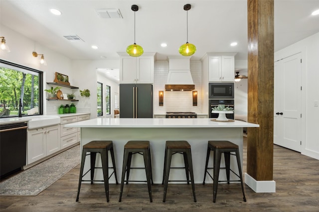 kitchen with premium range hood, backsplash, open shelves, visible vents, and black appliances
