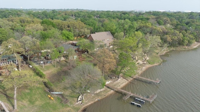 birds eye view of property featuring a forest view and a water view