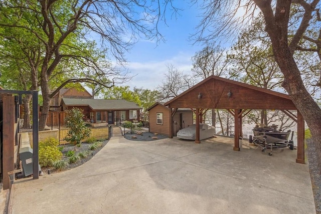 view of community featuring a carport, driveway, and fence