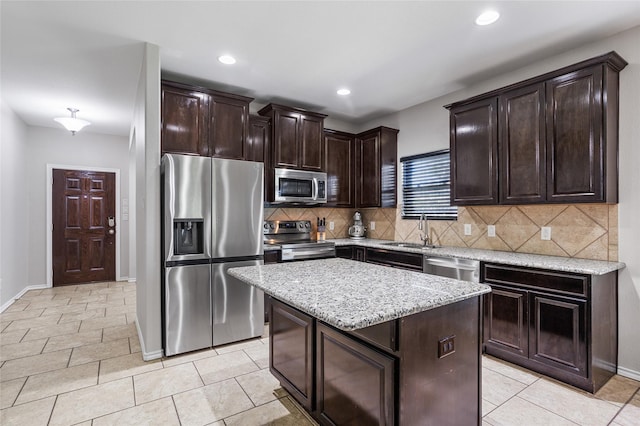 8312 White Hart Dr, Fort Worth, TX 76179 - kitchen featuring dark brown cabinetry, a center island, backsplash, appliances with stainless steel finishes, and a sink