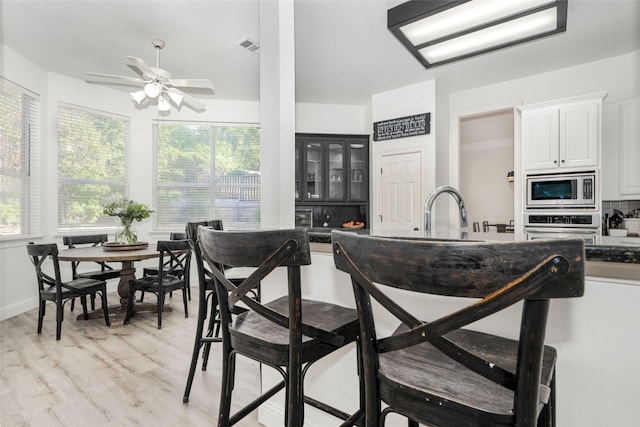 kitchen featuring a ceiling fan, a sink, appliances with stainless steel finishes, and dark countertops