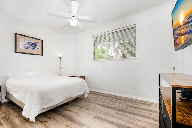 bedroom with baseboards, light wood finished floors, and ceiling fan