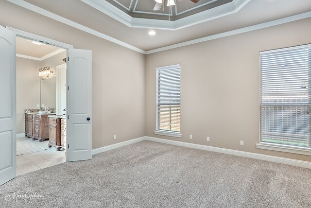 spare room with crown molding, a healthy amount of sunlight, light colored carpet, and a ceiling fan