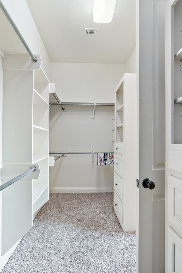 walk in closet featuring light colored carpet and visible vents