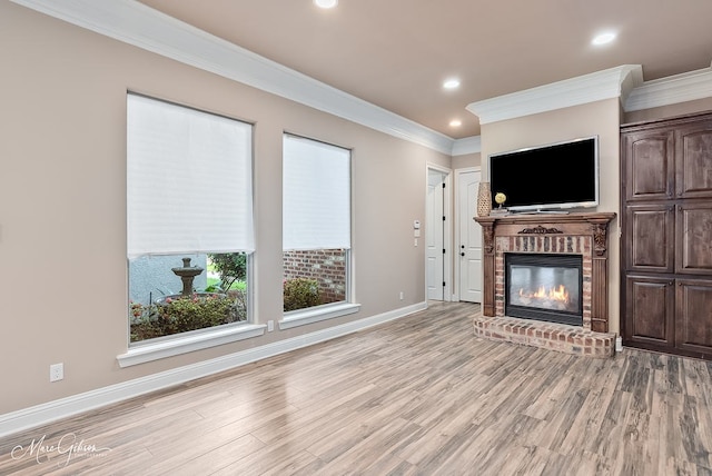 unfurnished living room featuring light wood-style floors, a fireplace, ornamental molding, recessed lighting, and baseboards