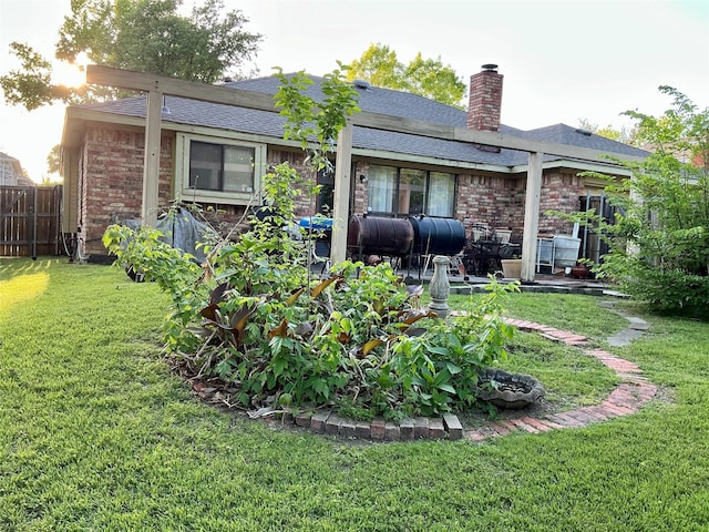 612 Desoto Dr, Desoto, TX 75115 - back of property featuring roof with shingles, a chimney, brick siding, fence, and a lawn