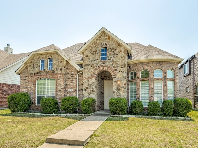 610 Crockett Dr, Lavon, TX 75166 - french country style house with brick siding, a front lawn, stone siding, and roof with shingles