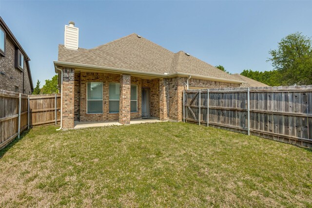 610 Crockett Dr, Lavon, TX 75166 - rear view of house featuring a chimney, a patio area, brick siding, a fenced backyard, and a lawn