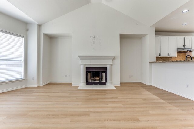 610 Crockett Dr, Lavon, TX 75166 - unfurnished living room with recessed lighting, a fireplace with raised hearth, light wood-style floors, and lofted ceiling