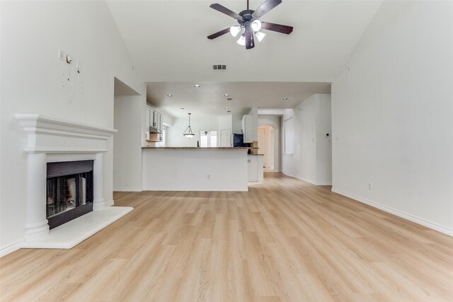 610 Crockett Dr, Lavon, TX 75166 - unfurnished living room featuring baseboards, a fireplace with raised hearth, visible vents, ceiling fan, and light wood finished floors