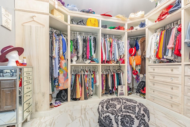 walk in closet with marble finish floor