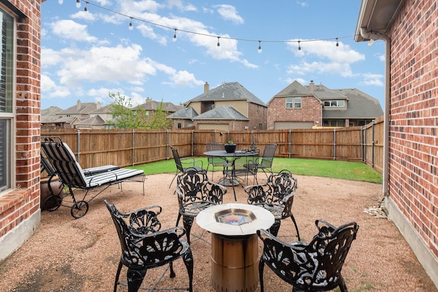 view of patio / terrace with an outdoor fire pit, a fenced backyard, and a residential view