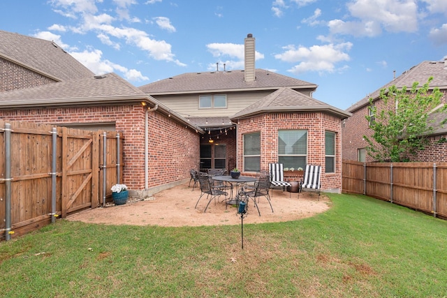 back of property with a yard, a fenced backyard, brick siding, a chimney, and a shingled roof