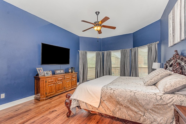 bedroom with baseboards, light wood-type flooring, and a ceiling fan