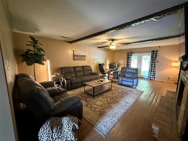 2909 Oakridge Dr, Corsicana, TX 75110 - living area featuring a textured ceiling, wood finished floors, a ceiling fan, beam ceiling, and french doors