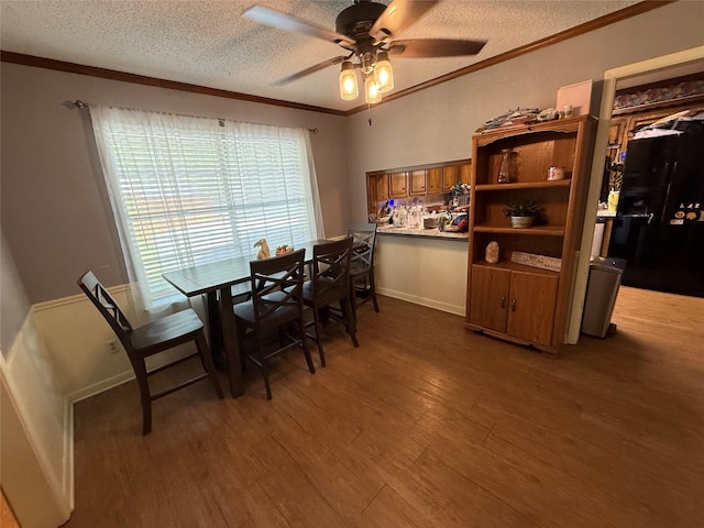 2909 Oakridge Dr, Corsicana, TX 75110 - dining room with wood finished floors, ceiling fan, crown molding, a textured ceiling, and baseboards