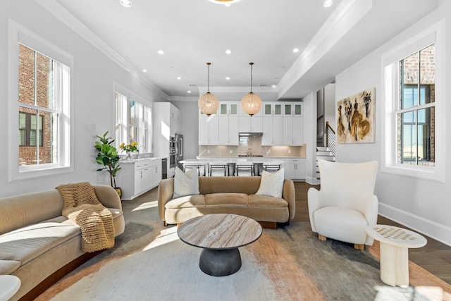 living area featuring dark wood finished floors, recessed lighting, ornamental molding, and a wealth of natural light