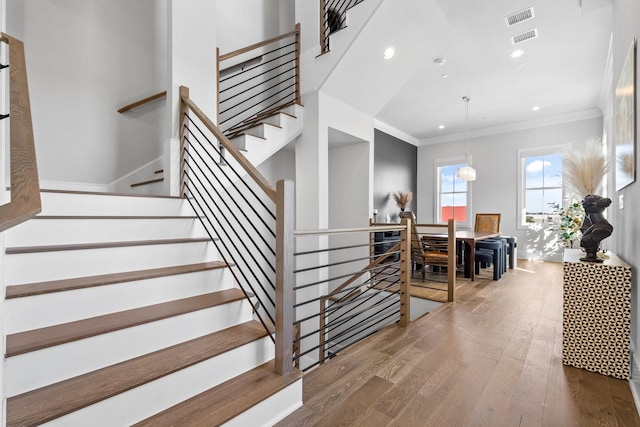 stairs with visible vents, ornamental molding, recessed lighting, and wood finished floors