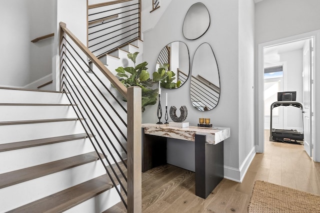 staircase with wood finished floors and baseboards