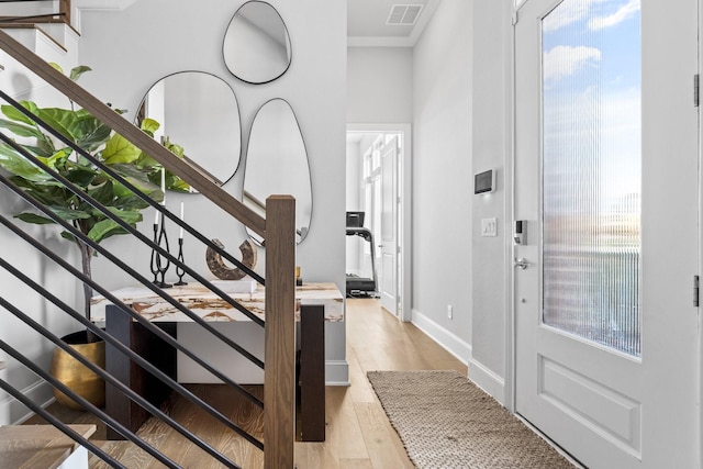 foyer entrance featuring stairway, visible vents, and light wood finished floors