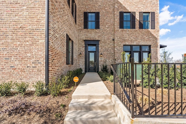 doorway to property featuring brick siding