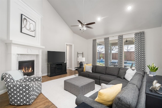 1128 Ellicott Dr, Celina, TX 75009 - living room with ceiling fan, wood finished floors, baseboards, a lit fireplace, and high vaulted ceiling