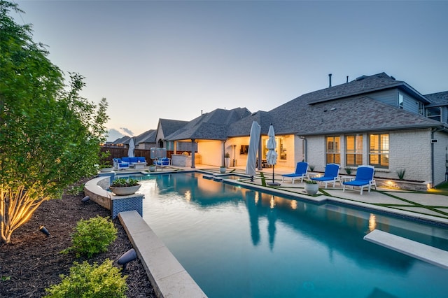1128 Ellicott Dr, Celina, TX 75009 - pool at dusk with a patio, fence, and a diving board