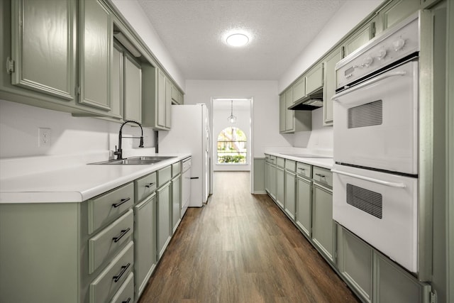 6516 Welch Ave, Fort Worth, TX 76133 - kitchen featuring green cabinetry, white appliances, a sink, under cabinet range hood, and a textured ceiling