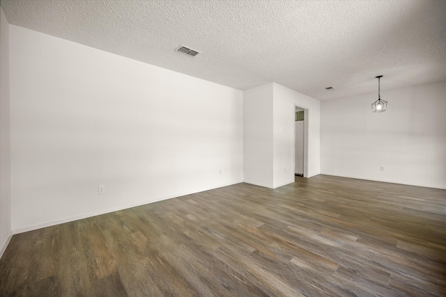 6516 Welch Ave, Fort Worth, TX 76133 - spare room featuring dark wood-style flooring, a textured ceiling, and baseboards